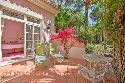 a patio with a table and chairs and flowers at Quinta Jacintina - My Secret Garden Hotel in Vale do Lobo
