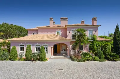 a large pink house with a driveway at Quinta Jacintina - My Secret Garden Hotel in Vale do Lobo