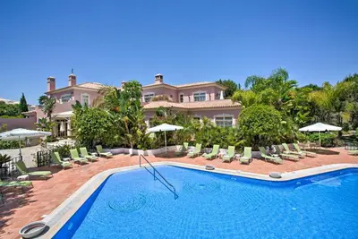 a large house with a swimming pool and chairs at Quinta Jacintina - My Secret Garden Hotel in Vale do Lobo