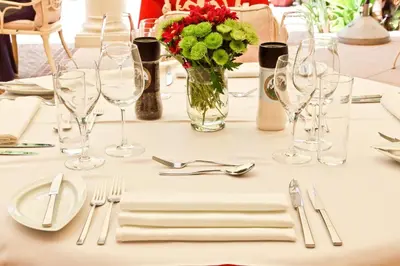 a table with glasses and a vase of flowers and silverware at Quinta Jacintina - My Secret Garden Hotel in Vale do Lobo