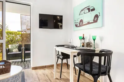 a dining room with a white table and black chairs at Modern Pool Apartment, Vilamoura in Quarteira