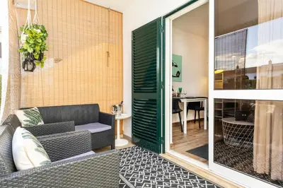 a small balcony with a couch and a table at Modern Pool Apartment, Vilamoura in Quarteira