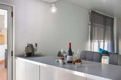 a kitchen with a counter with wine bottles and glasses at Maria Rita Faro Rooftop Apartment in Faro
