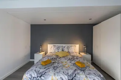 a bedroom with a large bed with yellow pillows at Maria Rita Faro Rooftop Apartment in Faro