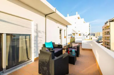 a balcony with chairs and tables on a building at Maria Rita Faro Rooftop Apartment in Faro