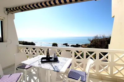 a balcony with a table with a view of the ocean at magnifique appartement sur la plage ... in Albufeira