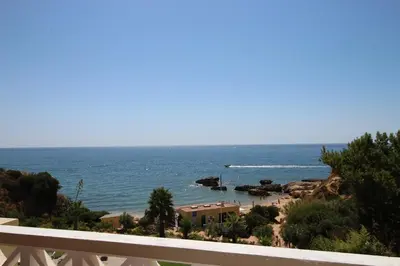 a view of a beach with a boat in the water at magnifique appartement sur la plage ... in Albufeira