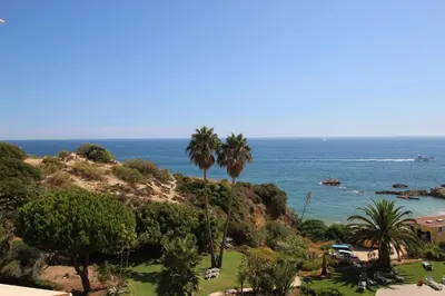 a view of a beach with palm trees and the ocean at magnifique appartement sur la plage ... in Albufeira