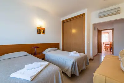 a hotel room with two beds and a table at Apartamentos Monte da Vinha I in Albufeira