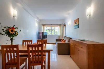 a kitchen and living room with a table and chairs at Apartamentos Monte da Vinha I in Albufeira