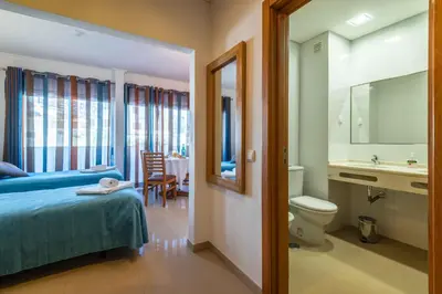 a bedroom with a bed and a toilet and a sink at Apartamentos Turisticos Monte da Vinha II in Albufeira