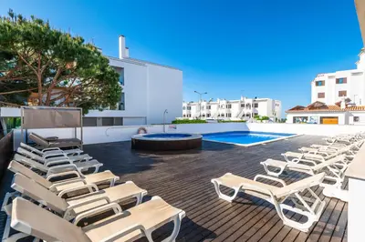 a group of lounge chairs and a swimming pool at Apartamentos Turisticos Monte da Vinha II in Albufeira