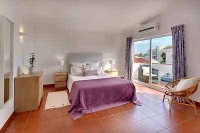 a bedroom with a bed and a large window at Villa Francella- Relaxing holidays in an ideal location by DreamvillasAlbufeira in Albufeira