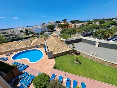 an aerial view of a resort with a swimming pool and chairs at Charming Ocean View Apartment in Albufeira