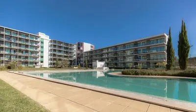 a swimming pool in front of two apartment buildings at Residence Golf Club by Garvetur in Vilamoura