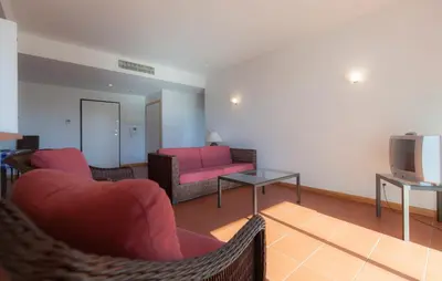 a living room with a couch and a tv at Residence Golf Club by Garvetur in Vilamoura