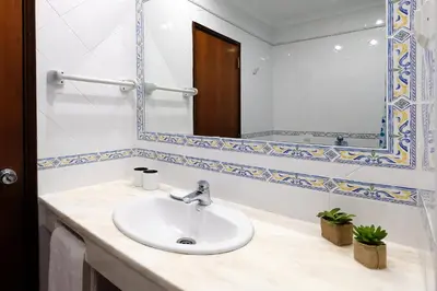 a bathroom with a sink and a mirror at LOTUS VILLA, Albufeira in Albufeira