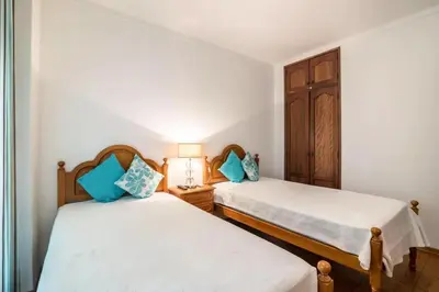 a bedroom with two beds with blue pillows at Charming Apartment in Quarteira - 50 m² - Terrace in Quarteira