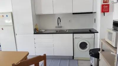 a kitchen with a sink and a washing machine at Apartment Girasol Front Beach Quarteira Algarve in Quarteira