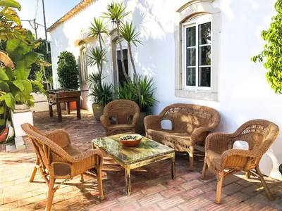 a patio with wicker chairs and a table at Quinta Da Ilda in Loulé