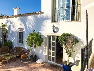 a white house with a patio with potted plants at Quinta Da Ilda in Loulé