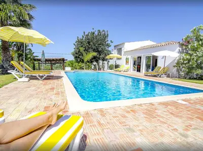 a woman laying on a chair next to a swimming pool at Quinta Da Ilda in Loulé