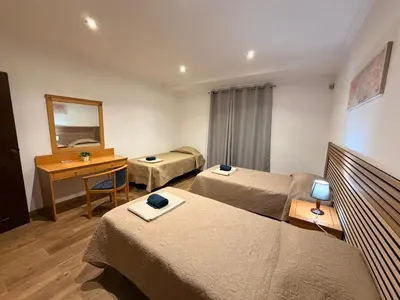a bedroom with a bed with a red bedspread and two lamps at Quinta Vita - Vila Uva in Almancil
