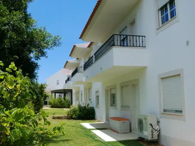 a white building with a balcony on the side at Charming apartment with shared pool in Albufeira - 60 m² in Albufeira