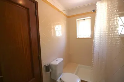 a bathroom with a toilet and a window and a shower at magnifique maison en resort près des plages in Albufeira