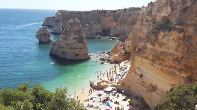 a group of people on a beach near the ocean at magnifique maison en resort près des plages in Albufeira