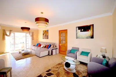 a living room with couches and chairs and a table at magnifique et spacieuse villa avec piscine privative in Albufeira