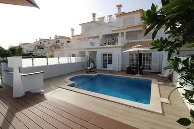 a villa with a swimming pool in front of a house at magnifique et spacieuse villa avec piscine privative in Albufeira