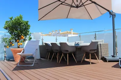 a patio with a table and chairs and an umbrella at magnifique et spacieuse villa avec piscine privative in Albufeira