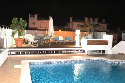 a swimming pool in front of a house at night at magnifique et spacieuse villa avec piscine privative in Albufeira