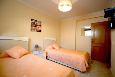 a bedroom with two beds with orange sheets at magnifique et spacieuse villa avec piscine privative in Albufeira
