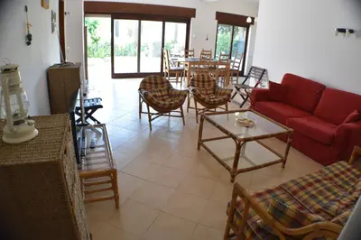 a living room with a red couch and chairs and a table at Villa Alexia - By Algarkasa in Albufeira