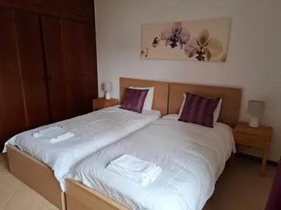 a bedroom with two beds with white sheets and purple pillows at Villa Alexia - By Algarkasa in Albufeira