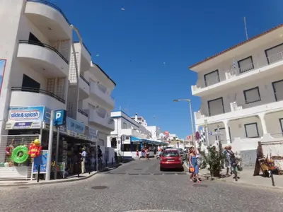 a group of people walking down a street with buildings at Villa Alexia - By Algarkasa in Albufeira