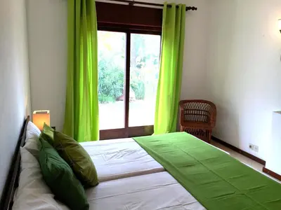 a bedroom with a bed with green curtains and a window at Villa Alexia - By Algarkasa in Albufeira