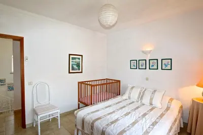 a bedroom with a bed and a chair at Villa Amelia 156 - Clever Details in Vilamoura
