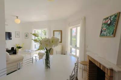 a living room with a vase of flowers on a table at Villa Amelia 156 - Clever Details in Vilamoura