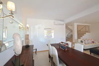 a dining room and living room with a table and chairs at Villa Gustas 150 - Clever Details in Vilamoura