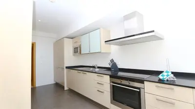 a kitchen with white cabinets and a stove top oven at Aquamar Sea View - Clever Details in Vilamoura