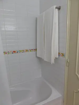 a white bathroom with a tub and a towel at Mirachoro Albufeira in Albufeira