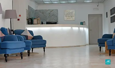 a waiting room with blue chairs and a white wall at Mirachoro Albufeira in Albufeira