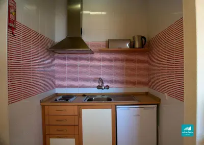 a small kitchen with a sink and red tiles at Mirachoro Albufeira in Albufeira