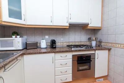 a kitchen with white cabinets and a stove top oven at São Rafael Beach Villa- D´alma Rafaella in Albufeira