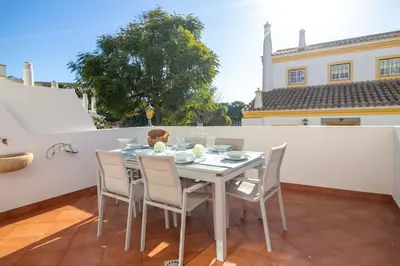 a table and chairs on the balcony of a house at São Rafael Beach Villa- D´alma Rafaella in Albufeira