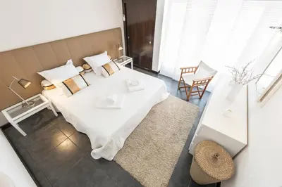 a bedroom with a bed and a table and chairs at Victory Village T1 & Mezzanine in Quinta do Lago