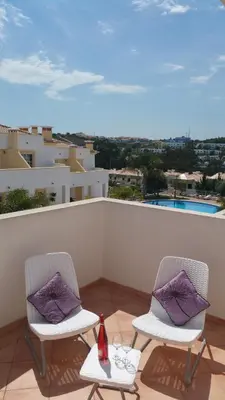 two chairs with purple pillows sitting on a balcony at Sergio s Place - FARM VILLAGE - By Algarkasa in Albufeira